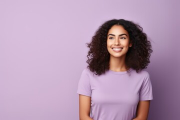 Portrait of a smiling young african american woman with curly hair, on purple background