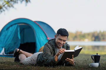 Man read book while traveler with camping. Concept of modern people lifestyle in working