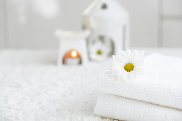 White towels with chamomile flower and aroma lamp, candle. Spa and wellness or beauty salon,...
