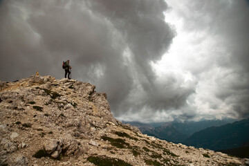 Man traveler traveling alone in breathtaking landscape of Dolomites Mounatains. Travel lifestyle wanderlust adventure concept.