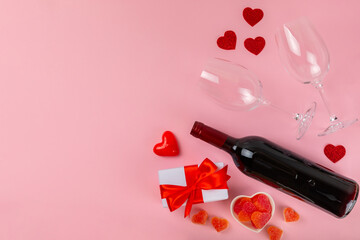 Valentine's Day concept.Valentine's Day background. Gifts, candles, confetti, envelope - postcard, candy, glasses, wine and a bouquet of roses on a pink background. Flatley.Valentine's day celebration