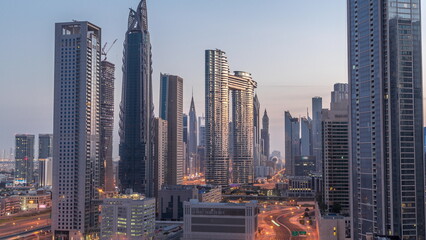 Many towers and skyscrapers with traffic on streets in Dubai Downtown and financial district night to day timelapse.