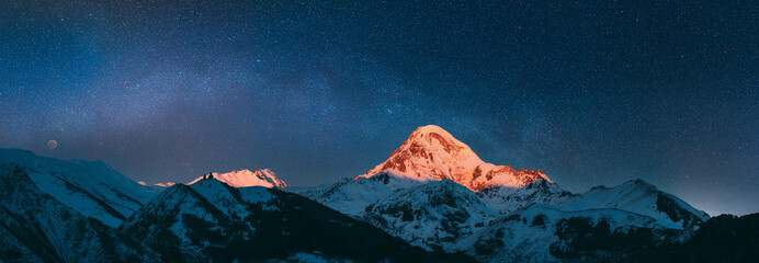 Stepantsminda, Gergeti, Georgia. Mount Kazbek Covered Snow In Winter Sunrise. Morning Dawn Colored...