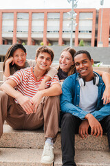 Vertical portrait of a group of real multiracial high school young students smiling and looking at...
