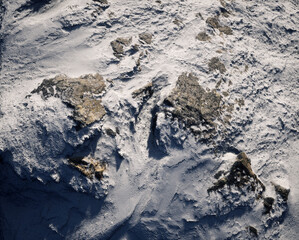 Aerial of rocky terrain covered in snow.