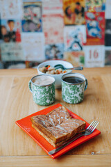 Kopitiam breakfast menu set contains a toast and two cup of coffee with bokeh background
