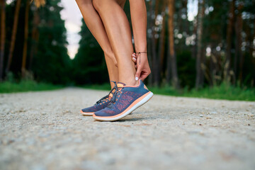 Close-up of female runner touching achilles tendon. Achilles tendonitis injury - obrazy, fototapety, plakaty