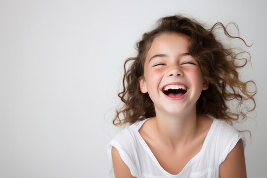 Naklejki Portrait of a happy laughing child girl isolated over white background