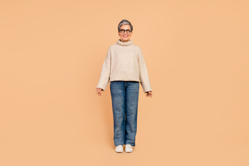 Full size photo of cheerful nice aged person good mood standing posing isolated on beige color...