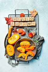 Banner: hello autumn. Orange pumpkins on a stone table, holiday decoration. Pumpkin menu. Top view.