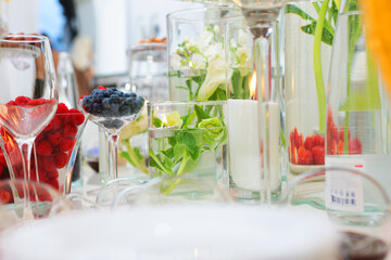 Light snacks and berries at the buffet. Concept of public catering. Raspberries and blueberries in a glass container.