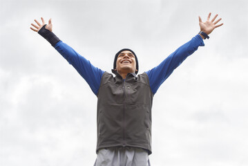 Happy man, runner or hands up for celebration in training adventure, exercise or workout success. Excited, sky or healthy hiker with smile, gratitude or freedom for fitness to explore nature outdoors © Alexandra/peopleimages.com