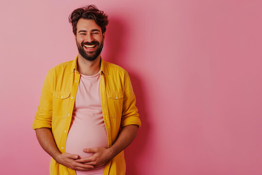 pregnant trans man with a big belly on a pastel pink background
