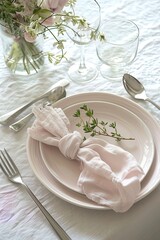 Sophisticated table setting with elegant dinnerware and a floral touch. Suitable for dining decor inspiration. 