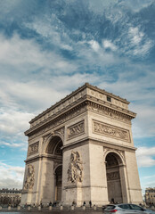 Fototapeta na wymiar Famous Arc de Triomphe (Triumphal Arch) at the city center of Paris and traffic trails in Chaps Elysees. Symbol of the glory and historical heritage, Iconic touristic architectural landmark, Tourism a