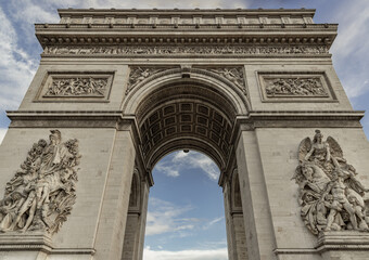 Fototapeta na wymiar Famous Arc de Triomphe (Triumphal Arch) at the city center of Paris. Symbol of the glory and historical heritage, Iconic touristic architectural landmark, Tourism and travel concept. Selective focus.