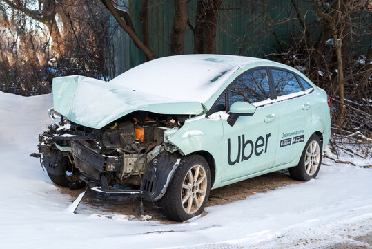 Kyiv, Ukraine. January 12, 2024. Wrecked car of Uber taxi after a head on collision in a parking lot. broken car after an accident in winter