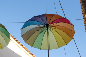 Colorful Umbrellas hanging in the air on the street in Aegina, Greece