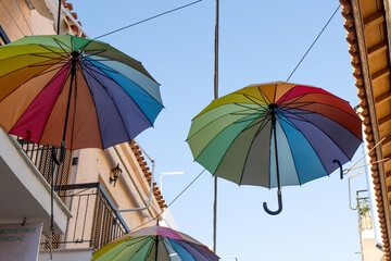 Colorful Umbrellas hanging in the air on the street in Aegina, Greece
