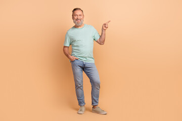 Full body photo of cheerful cool man indicate finger empty space proposition ad isolated on beige color background