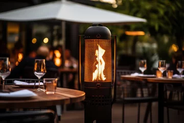 Fotobehang restaurant terrace with outdoor heaters with fire flame closeup. Gas heating equipment. Romantic date. Europe in winter, gas prices inflation. © Dina