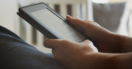 Woman reading an ebook on a reader with an e-ink display - 707864224