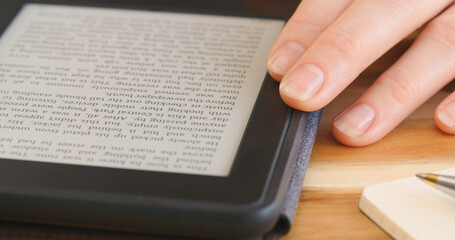 Woman reading an ebook on a reader with an e-ink display - 707864269