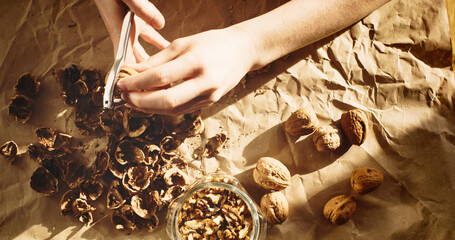 Close-up shot of a woman removing walnut kernels from their shells - 707864657