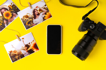 Photo camera with colorful printer photos on yellow background
