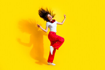 Fototapeta na wymiar Full length photo of dreamy excited lady wear white t-shirt earphones enjoying disco flying hair isolated yellow color background
