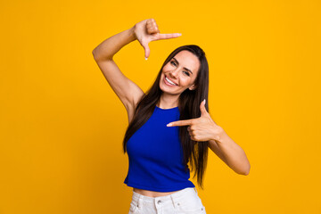 Photo of cheerful positive lady dressed blue top showing arms photo gesture isolated yellow color...