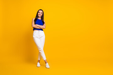 Fototapeta na wymiar Full length photo of cheerful good mood lady dressed blue top arms folded empty space isolated yellow color background