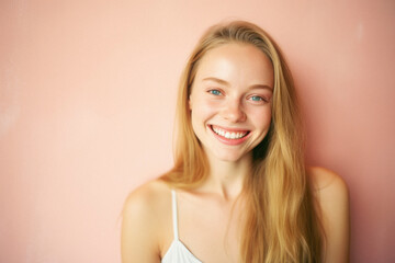 Portrait of a beautiful young girl with blond hair on a pink background