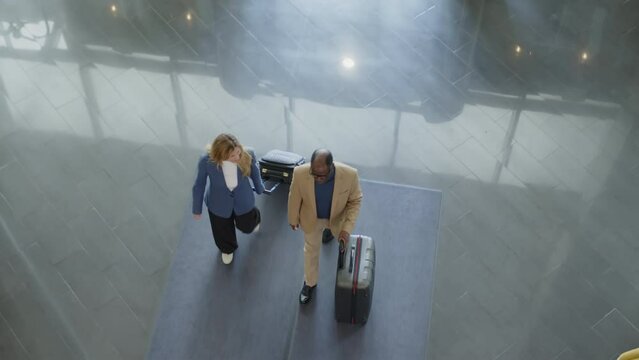 Top Down Shot Of Business People Walking With Suitcases Through Hotel Lobby After Arrival