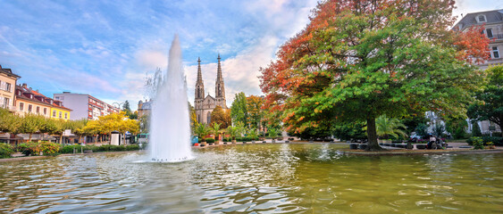 Panoramic view of pond with fountain and city church in Baden-Baden. Germany
