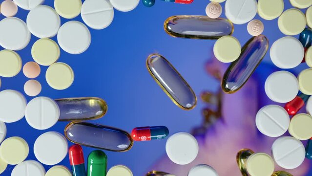 Close-up shot hand pouring omega 3 fish oil capsules vitamine D3 vitamin E capsules on flat surface covered with pills