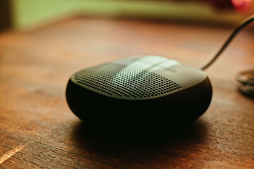 closeup photo of a black wireless speaker on a wooden table - 707924486