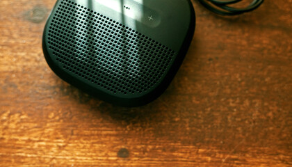 closeup photo of a black wireless speaker on a wooden table - 707924498