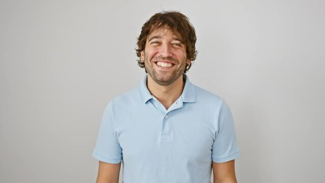 Happy young caucasian man sticking tongue out with hilarious joy, standing isolated on white background, showing a funny face expression