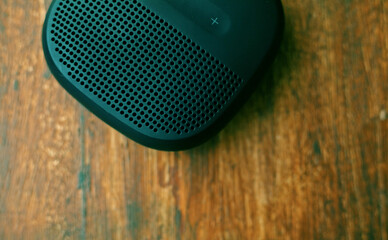 closeup photo of a black wireless speaker on a wooden table - 707924619