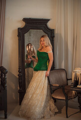 Medieval romantic style. Woman in evening beige dress and green silk corset