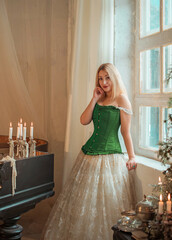 Medieval romantic style. Woman in evening beige dress and green silk corset
