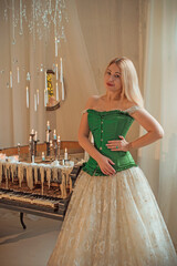 Medieval romantic style. Woman in evening beige dress and green silk corset