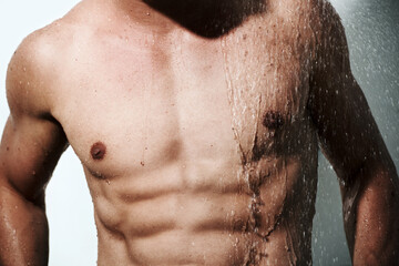 Closeup, muscular man or wet with body, hygiene or fitness with abs, routine or wellness on studio...