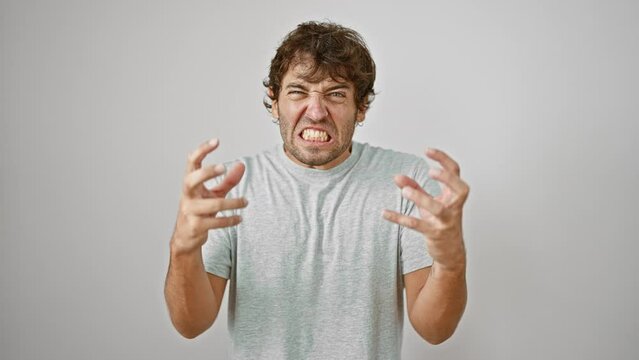 Pissed-off young man with a mad expression, shouting in flashy t-shirt, veins popping, arms raised in fury. a picture-perfect frustration. white isolated background.