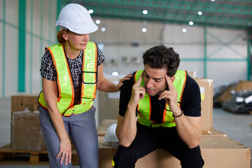 male worker feeling tired from work and coworker helping him in the warehouse storage