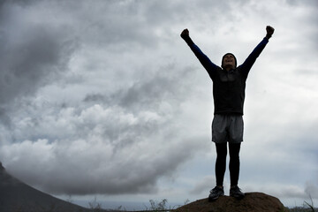 Happy man, mountain peak space or hands up for celebration in training, exercise or workout success. Excited athlete, sky mockup or hiker with energy, gratitude or freedom in nature for fitness
