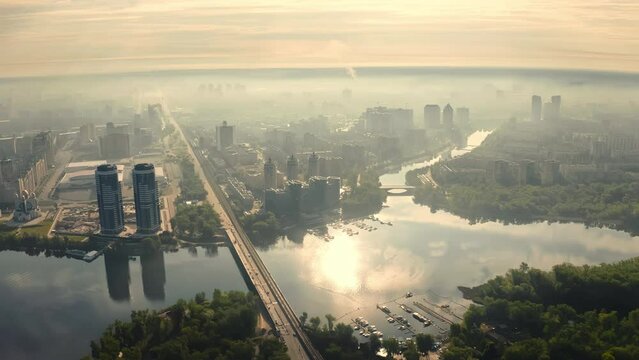 Aerial view city of Kyiv Ukraine at sunrise, bridge over a river with reflection and clouds