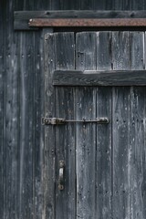 A detailed view of the door on a wooden building. This image can be used to showcase the rustic charm of architecture or as a background for various design projects