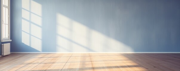 Light indigo wall and wooden parquet floor, sunrays and shadows from window